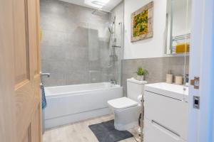 a bathroom with a white tub and a toilet and a sink at The Ramey in Sheringham +31 photos