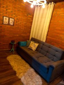 a couch in a living room with a brick wall at Chale Greifswald Pomerode in Pomerode
