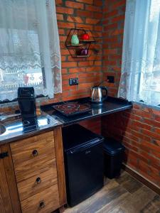 uma cozinha com um fogão e uma parede de tijolos em Chale Greifswald Pomerode em Pomerode
