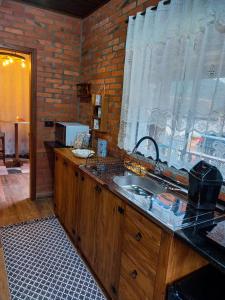 a kitchen with a sink and a brick wall at Chale Greifswald Pomerode in Pomerode