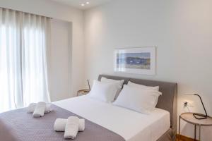 a white bedroom with a bed with towels on it at Luxury 1BR Flat in the Heart of Athens in Athens