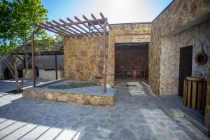 a patio with a hot tub in a stone building at Hotel West Way in Kutaisi