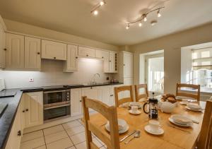 a kitchen with a wooden table with chairs and a dining room at Beckstones Yard in Hawes