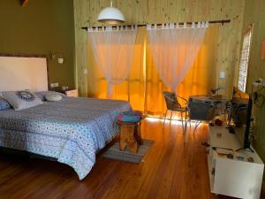 a bedroom with a bed and curtains and a table at Cabañas Namaskar in Villa Serranita +15 photos