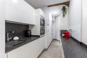a kitchen with white walls and a black counter top at Bilbao Arte V with parking by Aston Rentals in Bilbao
