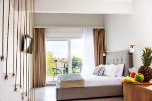 a bedroom with a bed and a balcony at Sithon Diamond Suites 1 in Nikiti +37 photos