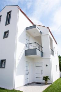 a white house with a balcony and a garage at Sithon Diamond Suites 1 in Nikiti