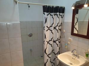 a bathroom with a shower curtain and a sink at Apart Hotel Marina Loft 214 in Coco +23 photos