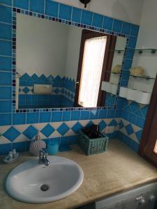 bagno con lavandino e specchio di Da Teresa a San Teodoro