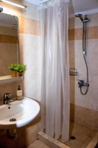 a bathroom with a shower curtain and a sink at Starry Coast Apartments in Nea Potidaea
