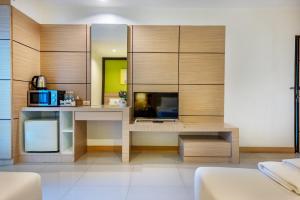 uma cozinha com armários de madeira e uma mesa com um micro-ondas em The Legacy Hotel em Nonthaburi