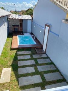a backyard with a small swimming pool next to a house at Casa Unamar Cabo Frio-RJ in Cabo Frio