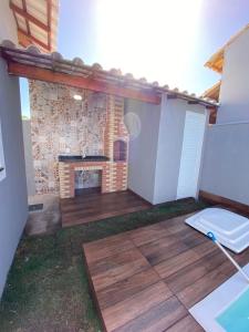 a patio with a brick fireplace and a deck at Casa Unamar Cabo Frio-RJ in Cabo Frio