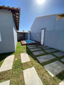 a backyard with a swimming pool next to a building at Casa Unamar Cabo Frio-RJ in Cabo Frio