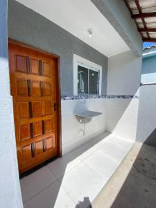 a bathroom with a sink and a wooden door at Casa Unamar Cabo Frio-RJ in Cabo Frio