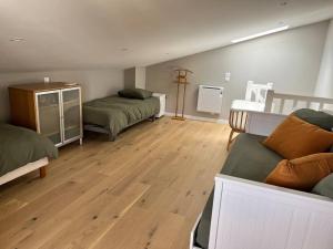 Camera con 2 letti e pavimento in legno. di Maison de village a Messery
