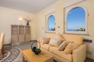 a living room with a couch and two windows at Villa Perla Apartments with balcony in Ičići