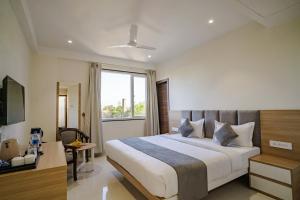 pokój hotelowy z łóżkiem i oknem w obiekcie THE MANGAL VIEW RESIDENCY - A Luxury Boutique Business Hotel w mieście Udaipur