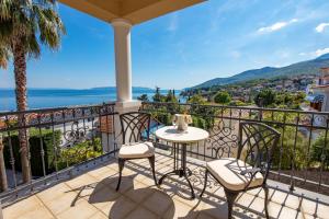 een patio met een tafel en stoelen op een balkon bij Villa Perla Apartments with balcony in Ičići