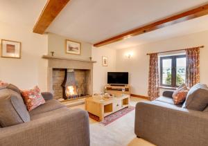 a living room with two couches and a fireplace at Ballowfield Barn in Carperby