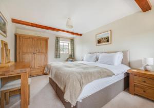 a bedroom with a large bed and a desk at Ballowfield Barn in Carperby