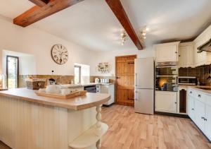 a kitchen with white appliances and a wooden ceiling at Ballowfield Barn in Carperby