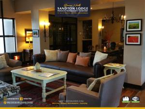 - un salon avec des canapés et une table dans l'établissement Sandton Lodge Rivonia, à Johannesbourg