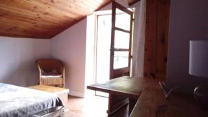 ein Schlafzimmer mit Bett, Schreibtisch und Fenster in der Unterkunft Le Gîte du Rocher - Auzat in Auzat