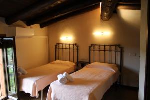 a room with two beds with white sheets at Apartaments Rurals Ai Manyac in San Miguel de Cruilles +33 photos
