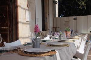 een lange tafel met borden en glazen erop bij La Souche Chambres et Table d'Hôtes in Saint-Chinian