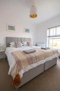 a white bedroom with a large bed in a room at The Ramey in Sheringham