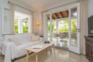 een woonkamer met een witte bank en een tafel bij Villa Campins in Port d'Alcudia