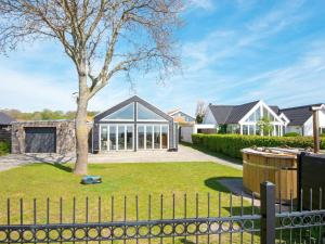 a house with a fence and a tree at 8 person holiday home in Odder-By Traum in Odder
