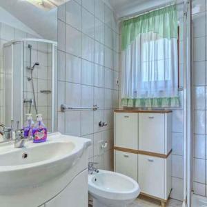 a white bathroom with a sink and a toilet at Apartments in Banjole/Istrien 34757 in Banjole