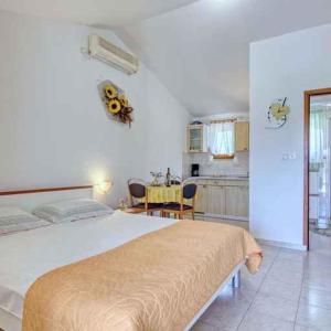 ein Schlafzimmer mit einem großen Bett und einem Tisch in der Unterkunft Apartments in Banjole/Istrien 34757 in Banjole