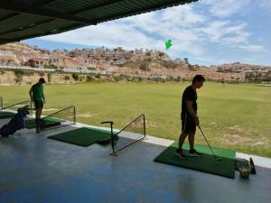 twee mannen die golfen op een putting green bij Golf Club La Marquesa best view ,, Home Aqma ,, in Ciudad Quesada