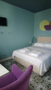 una habitación de hotel con 2 camas y una silla morada en 5RoomsPansiyon, en Edirne