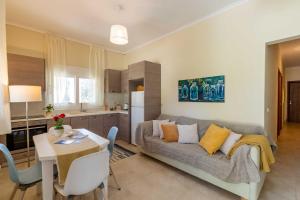 a living room and kitchen with a couch and a table at Kapella Country House in Vátos