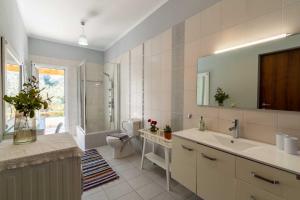 a bathroom with a sink and a toilet and a mirror at Kapella Country House in Vátos