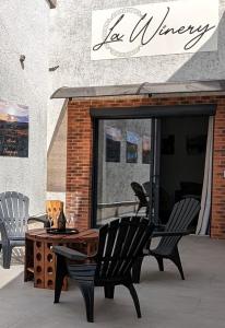 une terrasse avec deux chaises et une table en face d'un magasin dans l'établissement Gîte la Winery, à Romery