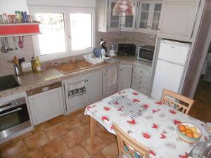 uma cozinha com uma mesa e um frigorífico branco em Chambre d'hôtes + piscine em Cavaillon