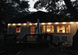 a house with an umbrella and lights on it at Cottage by the Sea: Pagnotto Shellback House in Oak Island