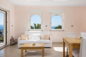 uma sala de estar com um sofá branco e duas janelas em Villa Perla Apartments with balcony em Ičići