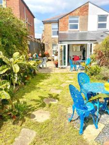 un patio con sillas azules y una mesa en un patio en Vista Do Mar - Cowes, en Cowes