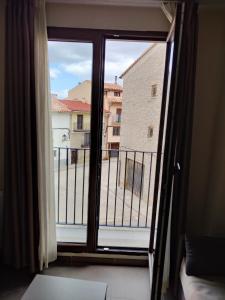 Habitación con ventana con vistas a un edificio en Aparthotel Castellfort, en Castellfort