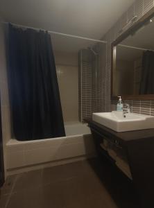 y baño con lavabo, ducha y bañera. en Aparthotel Castellfort en Castellfort
