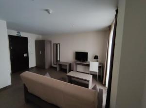 Una sala de estar con un sofá y un televisor. en Aparthotel Castellfort, en Castellfort 2 fotos más