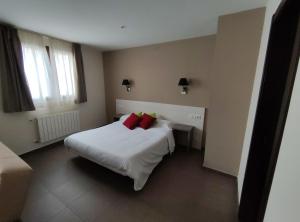 Un dormitorio con una gran cama blanca con almohadas rojas. en Aparthotel Castellfort, en Castellfort