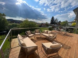 a deck with chairs and couches on a balcony at Villa Agatha in Épinal