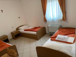 a small room with two beds and a window at Pansion Mate & DDS in Međugorje +24 photos